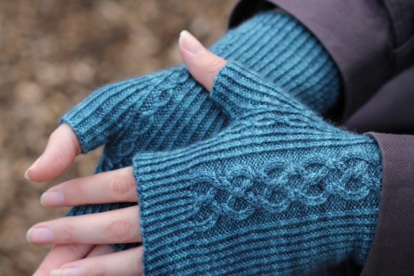 Twisted rib fingerless mitts with a large cable up the back of the hand and a narrow cable pattern that splits around the thumb