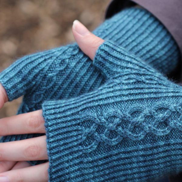 Twisted rib fingerless mitts with a large cable up the back of the hand and a narrow cable pattern that splits around the thumb