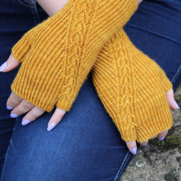 Twisted rib fingerless mitts with a narrow cable crossing the back of the hand from the inside of the wrist to the little finger. The little finger has a separate opening.