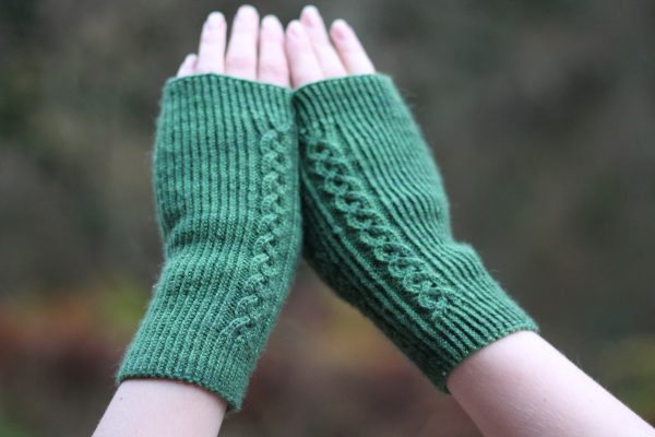 Twisted rib fingerless mitts with a large cable up the back of the hand and a narrow cable pattern that splits around the thumb