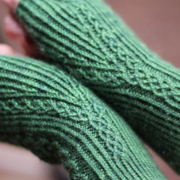A close up on the narrow cable pattern as it splits around the thumb