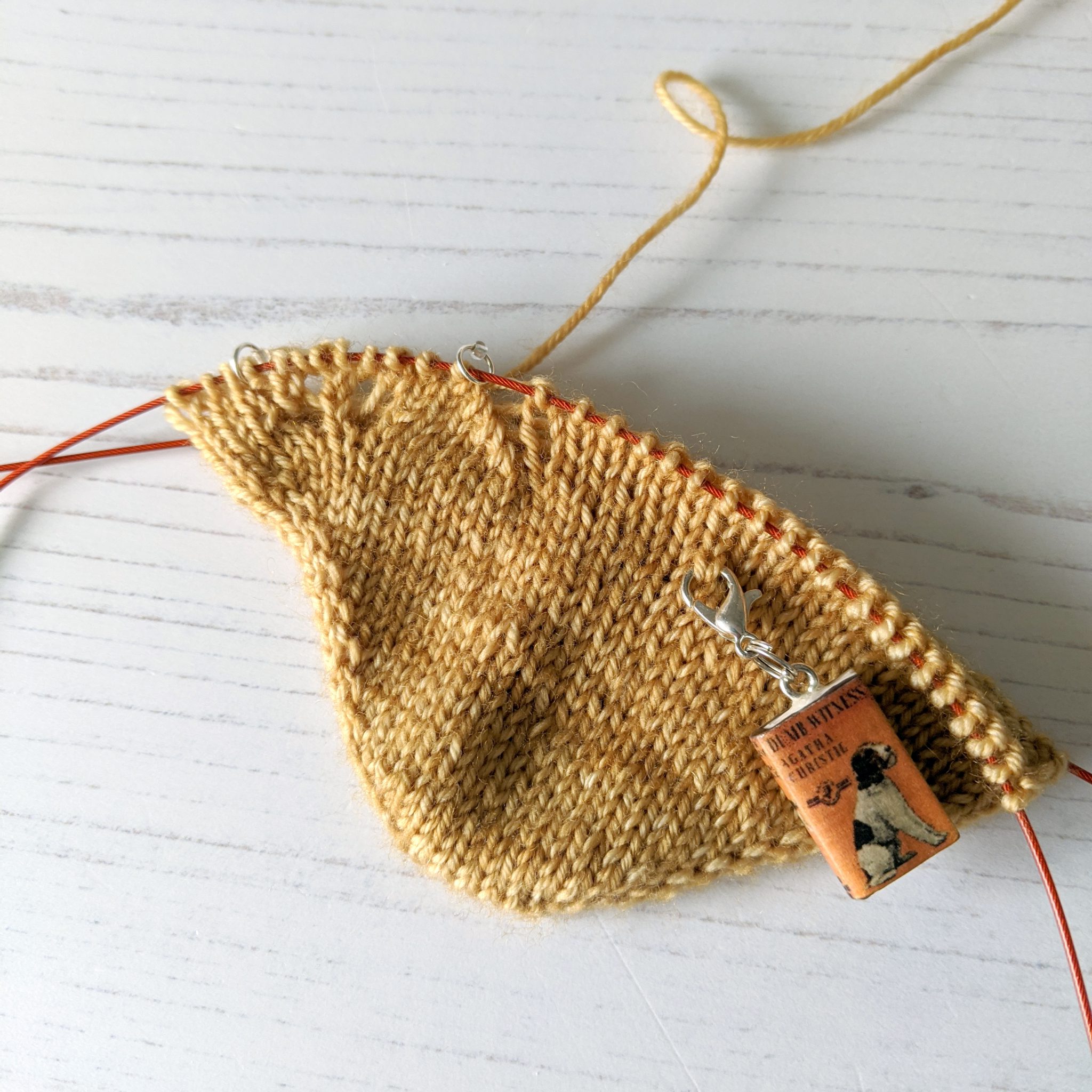 The in-progress knitted toe of a sock with a gap forming between a vertical line of decreases and the stitches to the right of it.
