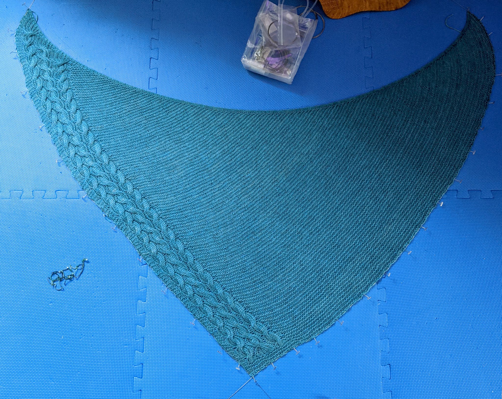 A photo showing the shawl during blocking