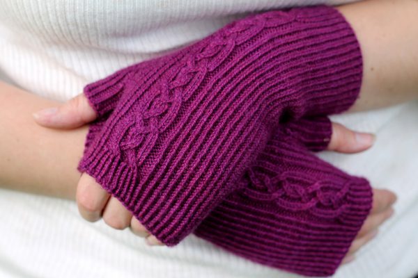 Twisted rib fingerless mitts with a large cable up the back of the hand and a narrow cable pattern that splits around the thumb (hands crossed)