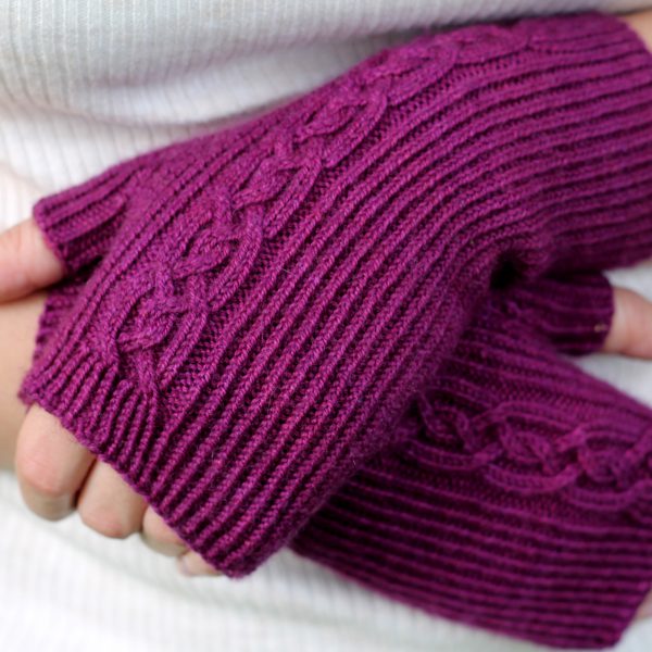 Twisted rib fingerless mitts with a large cable up the back of the hand and a narrow cable pattern that splits around the thumb (hands crossed)