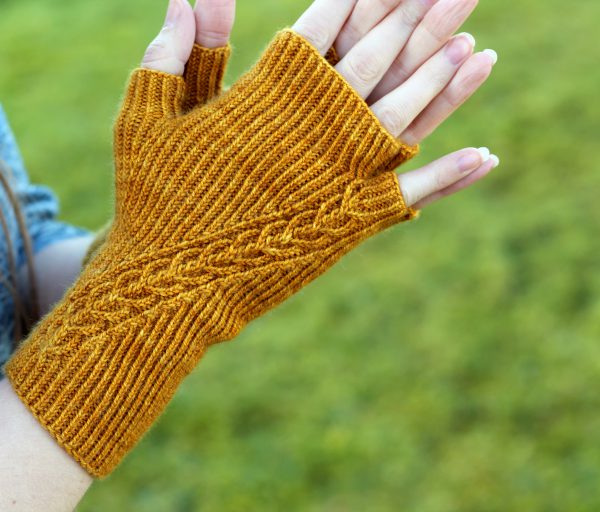 Twisted rib fingerless mitts with a narrow cable crossing the back of the hand from the inside of the wrist to the little finger. The little finger has a separate opening.