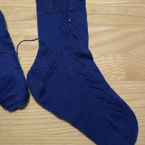 A Giuthas sock knit in dark blue yarn on a sock blocker