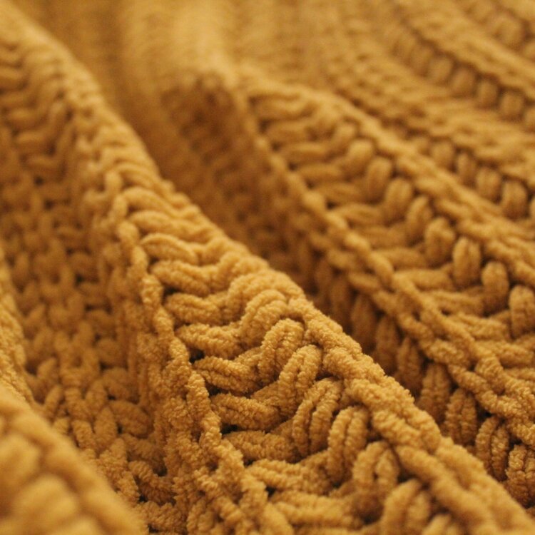 A piece of knitting in yellow yarn