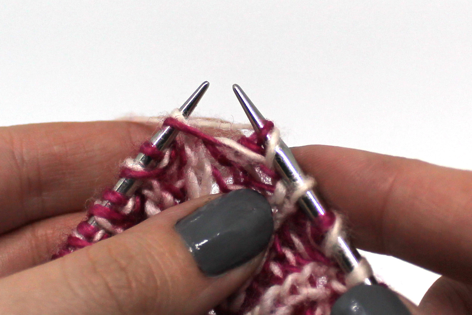 The yarn has been lifted over the needle to the back.