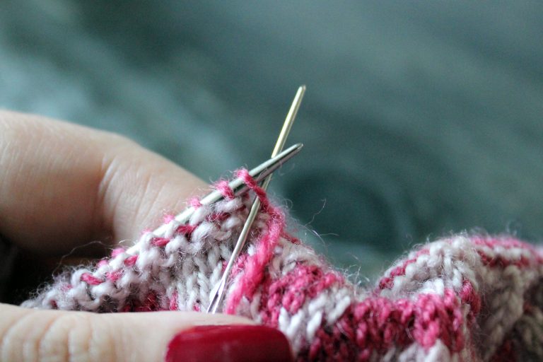 The tapestry needle has been inserted knitwise into the first stitch on the front needle