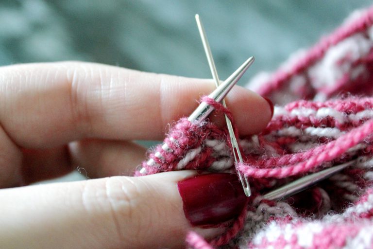 The tapestry needle has been inserted knitwise into the first stitch on the back needle