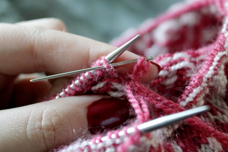 The tapestry needle has been inserted purlwise into the first stitch on the back needle