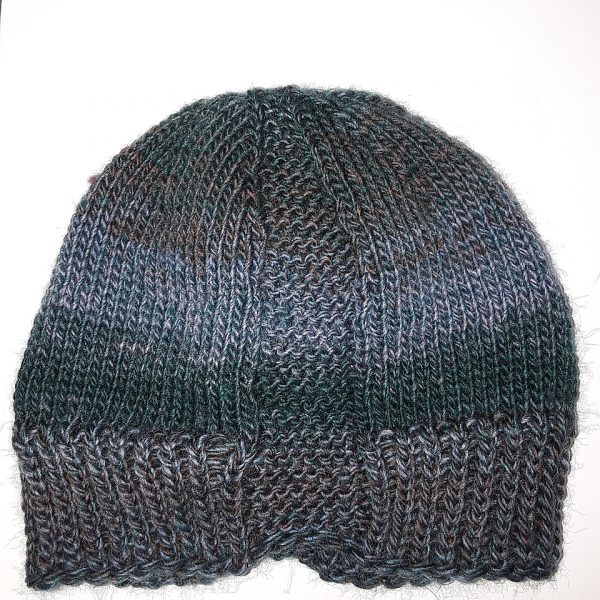 A hat knit with stripes in shades of brown and green and two garter stitch columns laid flat