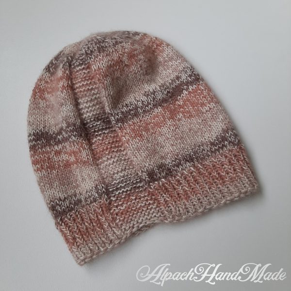 A hat knit with stripes in shades of brown and two garter stitch columns laid flat