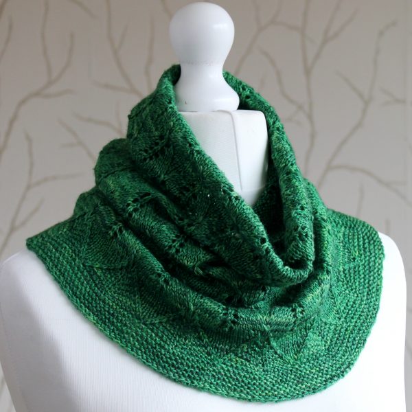 A green cowl with diamond shaped leaves and a wide lace border modelled on a mannequin