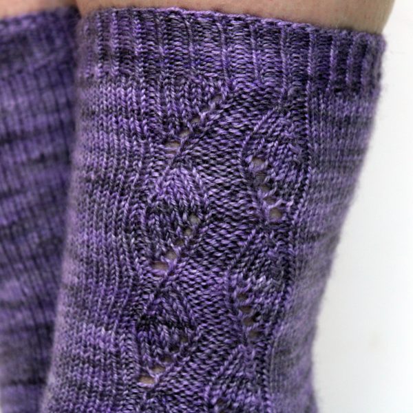 A close up showing how the lace pattern blends into the twisted rib cuff at the top of the sock