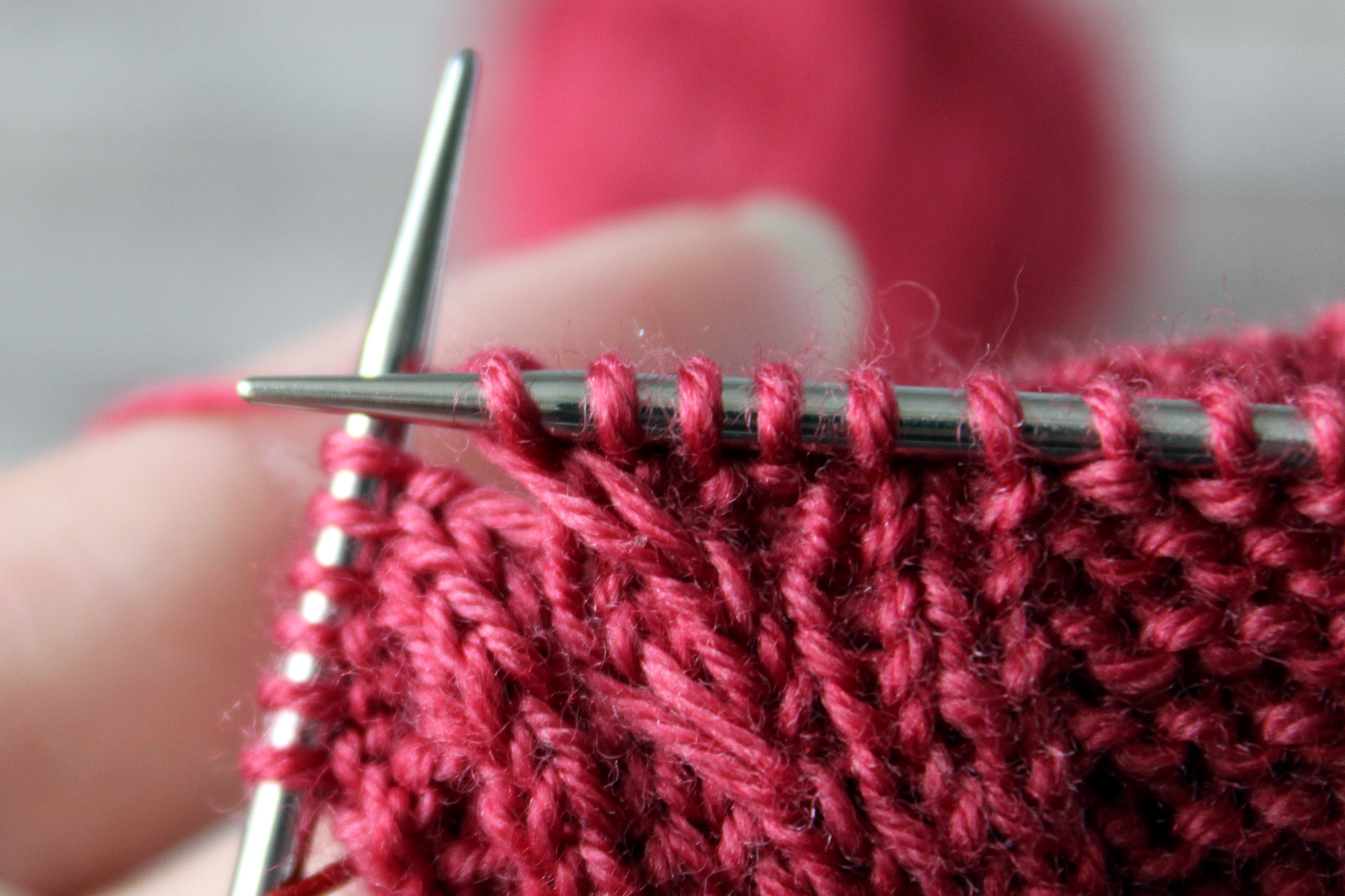 The three stitches have been knit onto the right hand needle completing the cable