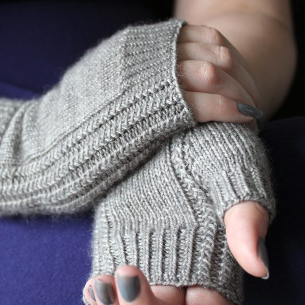Two fingerless mitts with a twisted rib cuff and a textured rib pattern up both sides and around the thumb, knitted in grey yarn.