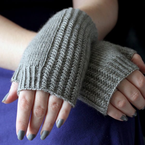 Two fingerless mitts with a twisted rib cuff and a textured rib pattern up both sides, knitted in grey yarn.