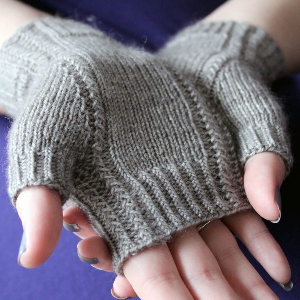 Two fingerless mitts with a twisted rib cuff and a textured rib pattern up both sides and around the thumb, knitted in grey yarn.