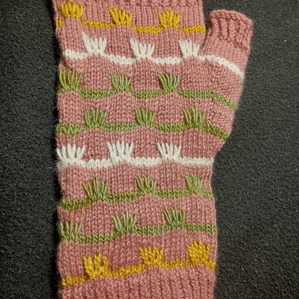 A fingerless mitt with coloured stripes and slipped stitches