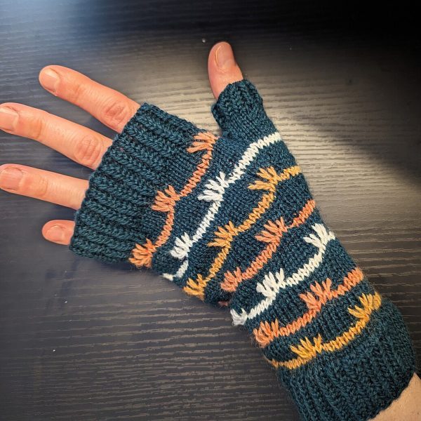 A fingerless mitt with coloured stripes and slipped stitches