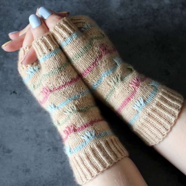The thumbs on a pair of mitts with coloured stripes and slipped stitches on the back of the hand