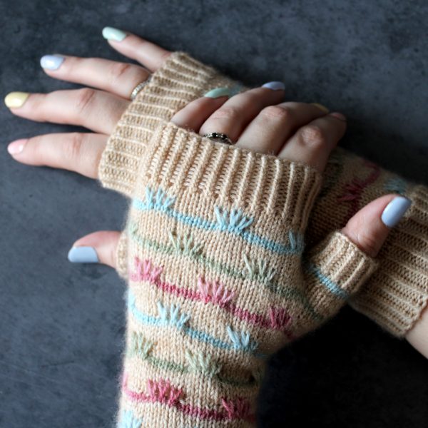 A pair of mitts with coloured stripes and slipped stitches on the back of the hand