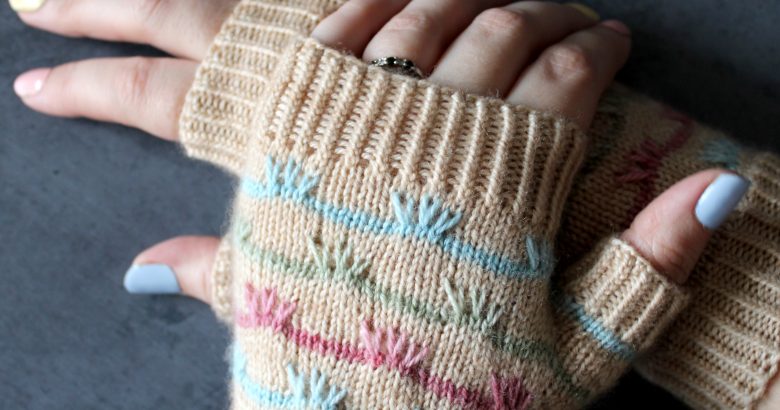 A pair of mitts with coloured stripes and slipped stitches on the back of the hand
