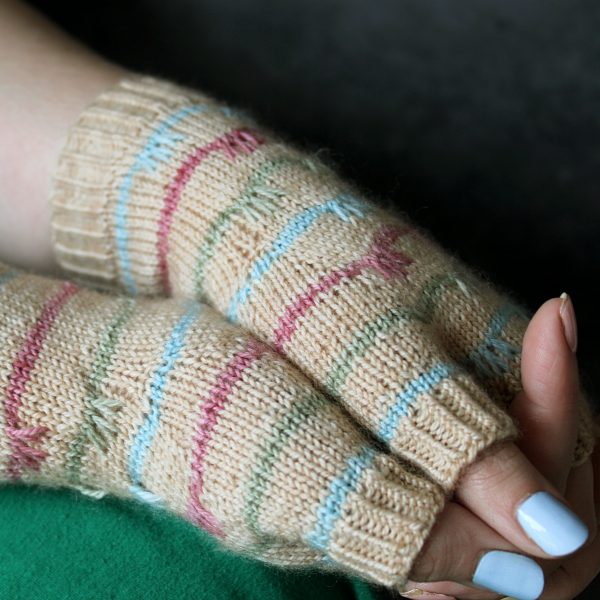 A close up on the thumbs on a pair of mitts with coloured stripes and slipped stitches