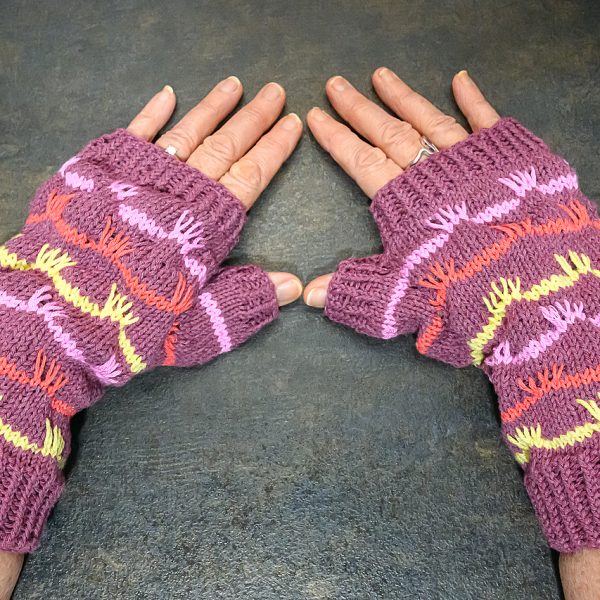 A pair of mitts with coloured stripes and slipped stitches