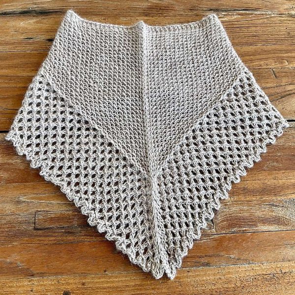 A cowlette with a textured body and lace border knit in light grey yarn