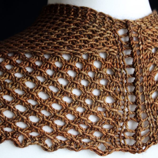 The back of a cowlette knit in brown yarn with a textured slipped stitch pattern on the body, a wide lace border and a rippling bind-off