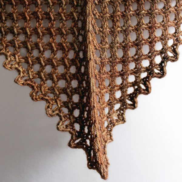 A close up on the lace border and bind off of a cowlette knit in brown yarn