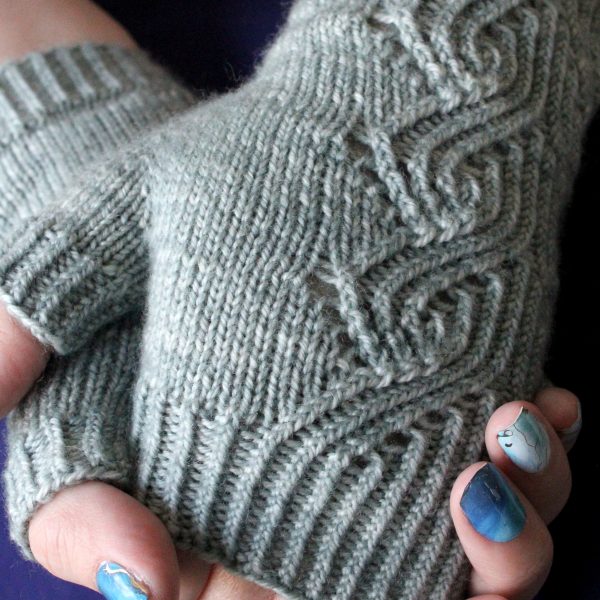 A pair of fingerless mitts with a twisted rib and lace faux cable pattern, knit in a pale blue yarn