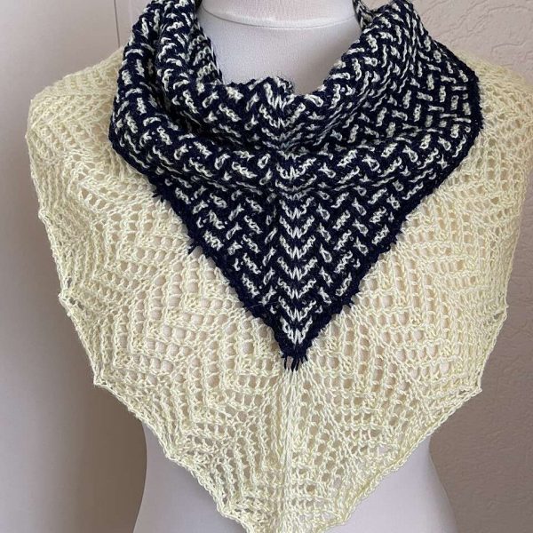 A cowlette with a mosaic body, knit in blue and white yarn, with a wide lace border knit in white.