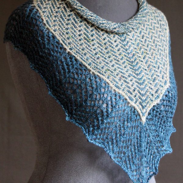 A cowlette with a mosaic body, knit in blue and white yarn, with a wide lace border knit in blue.