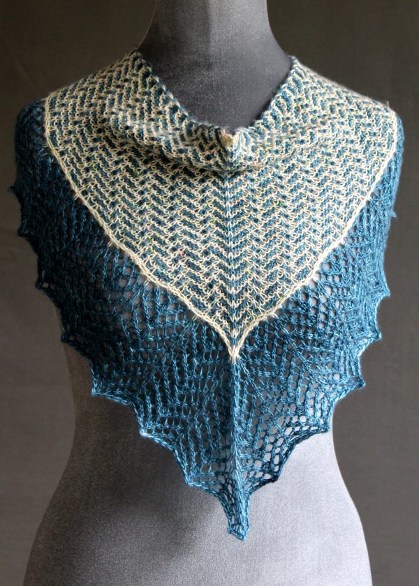 A cowlette with a mosaic body, knit in blue and white yarn, with a wide lace border knit in blue.