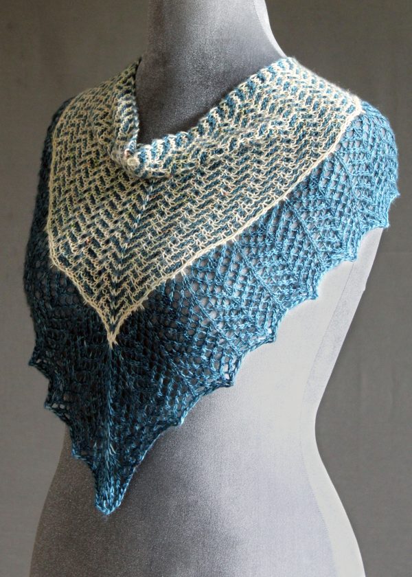 A cowlette with a mosaic body, knit in blue and white yarn, with a wide lace border knit in blue.