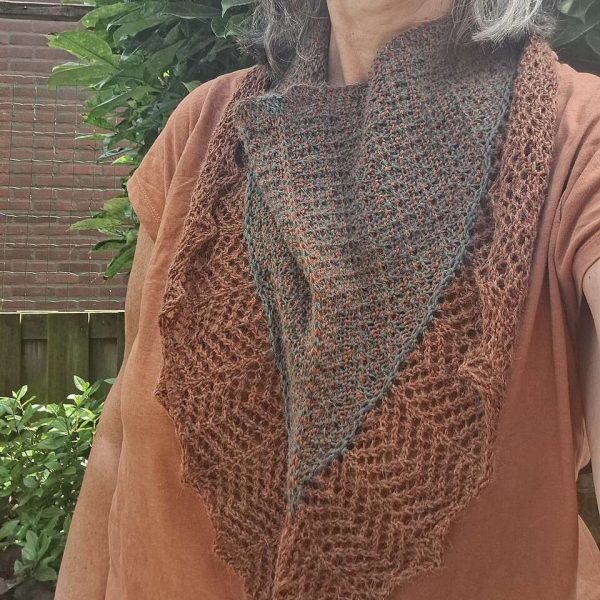 A cowlette with a mosaic body, knit in brown and dark brown yarn, with a wide lace border knit in brown.