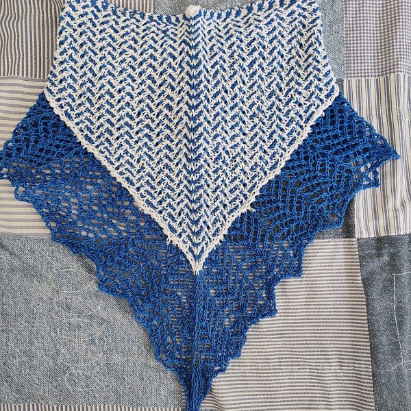 A cowlette with a mosaic body, knit in blue and white yarn, with a wide lace border knit in blue.